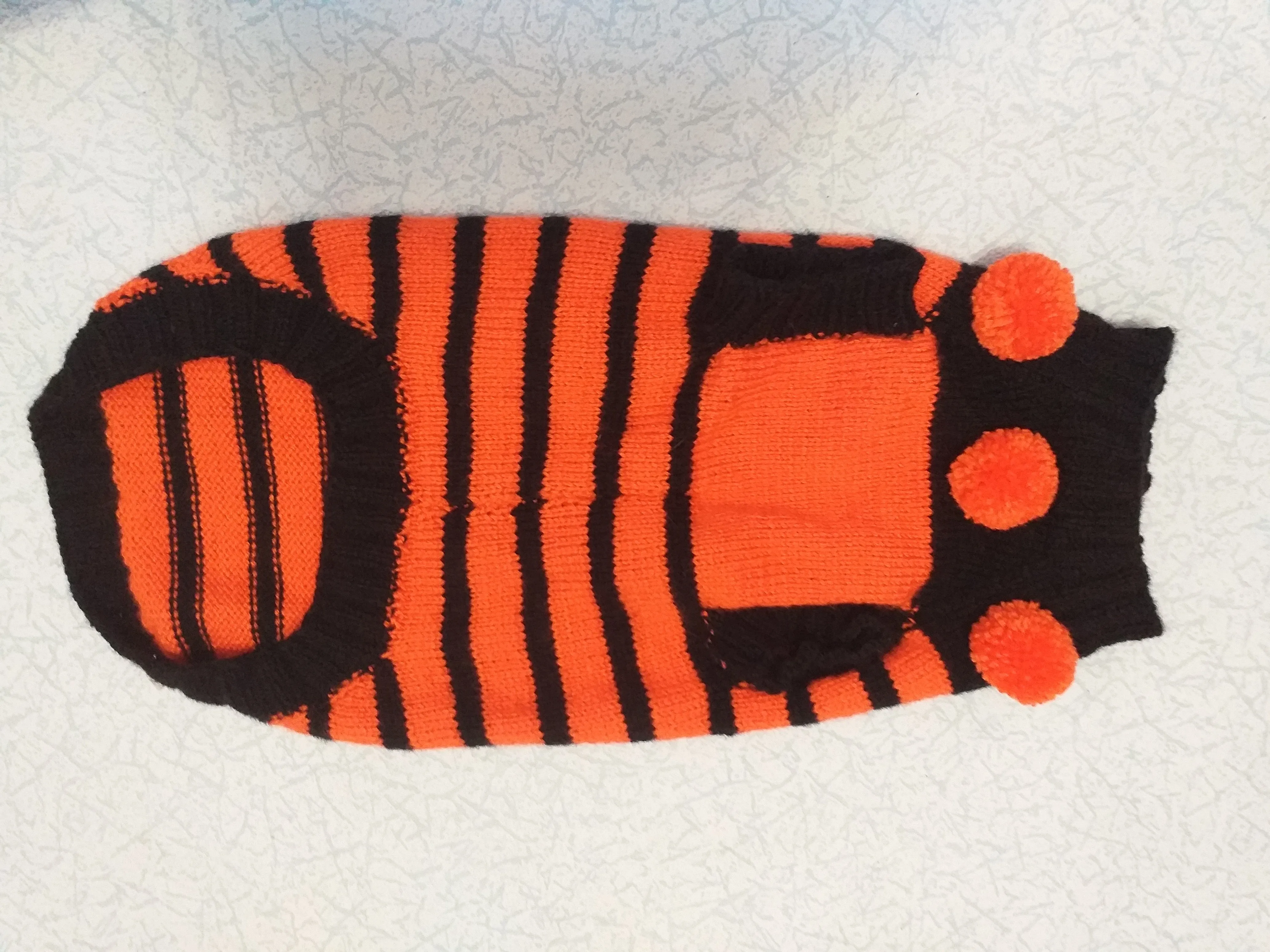 Orange and black striped knitted sweater with pompoms for dachshund or small dog