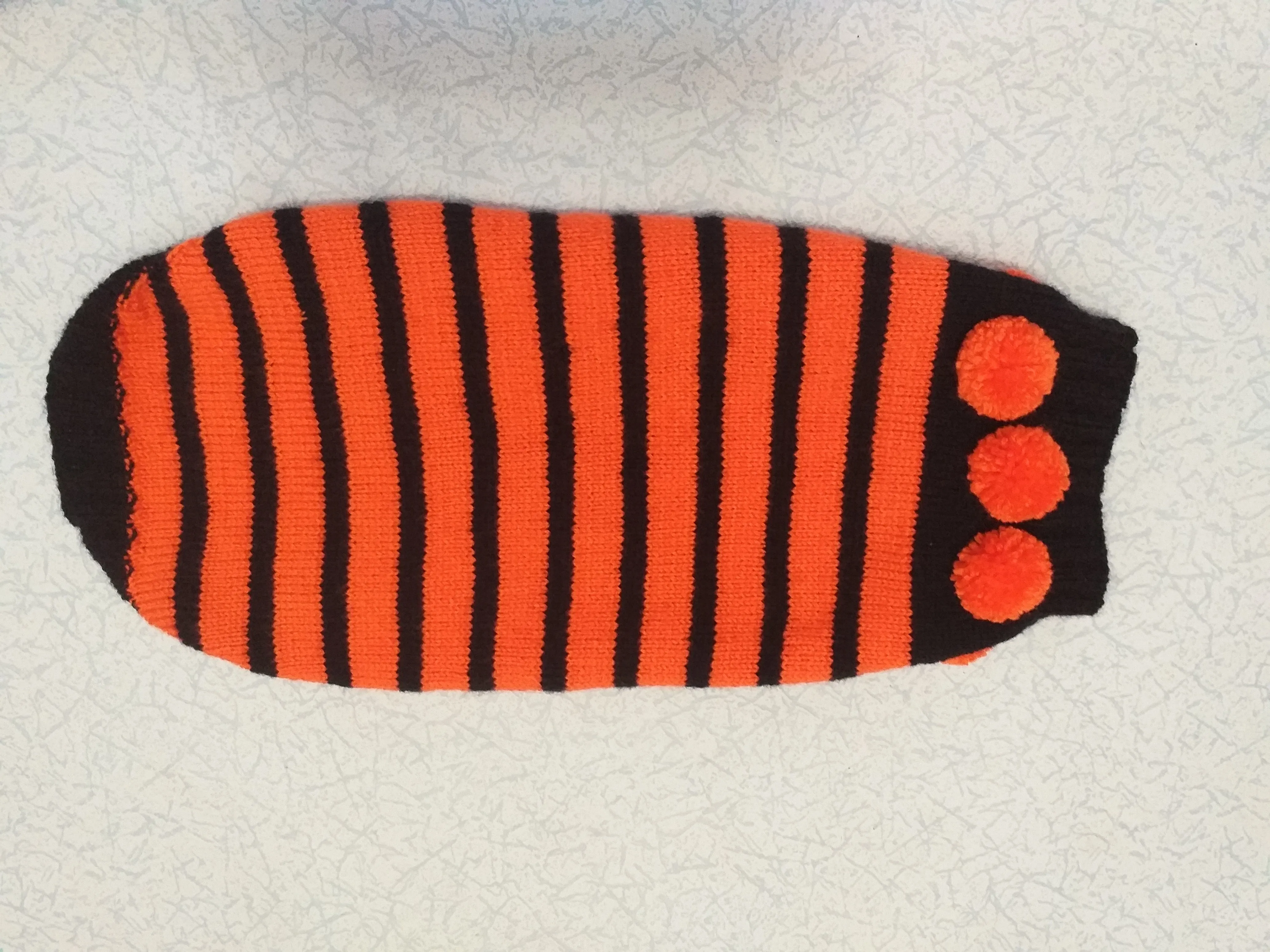 Orange and black striped knitted sweater with pompoms for dachshund or small dog